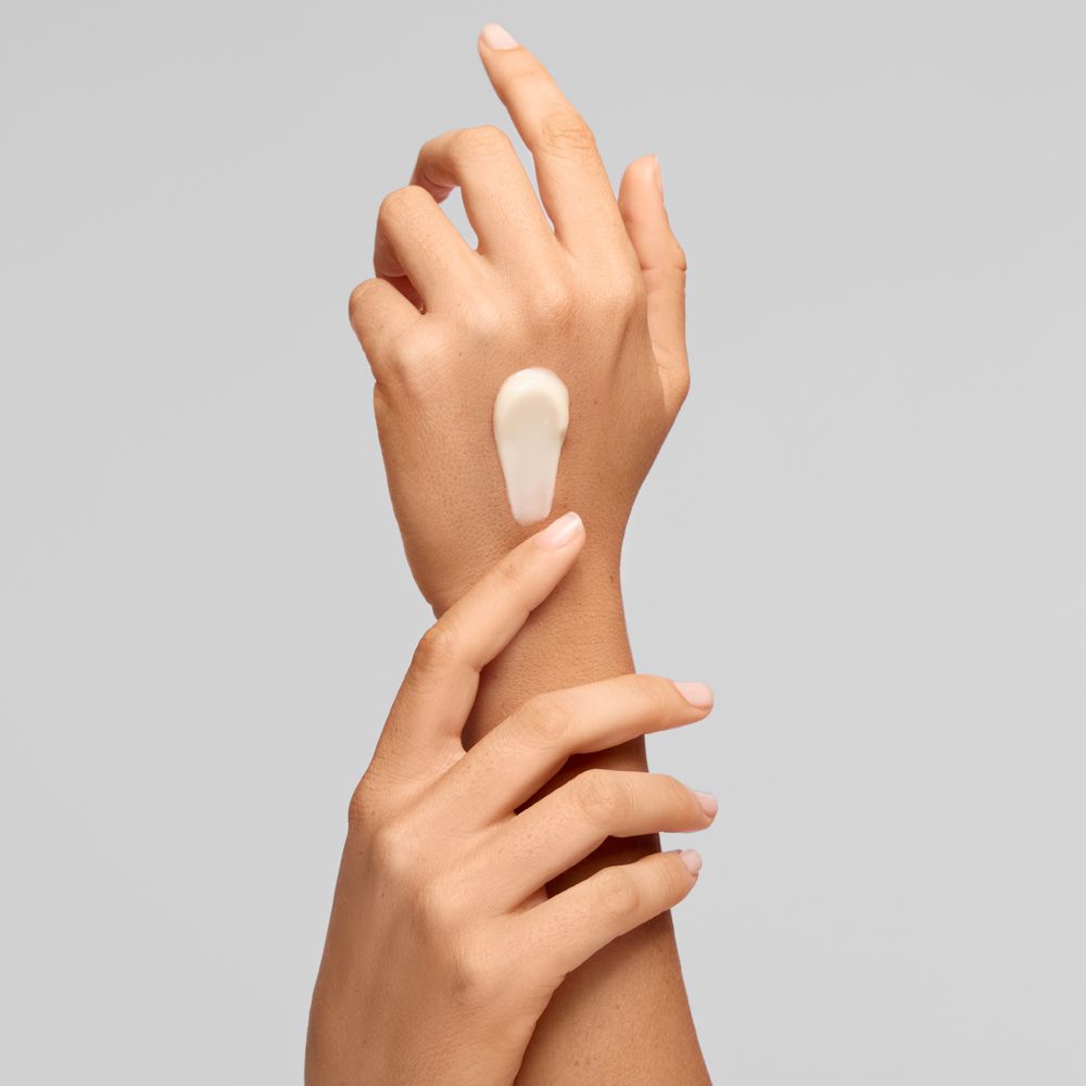 Eine weiße Creme ist auf dem Handrücken aufgetragen.