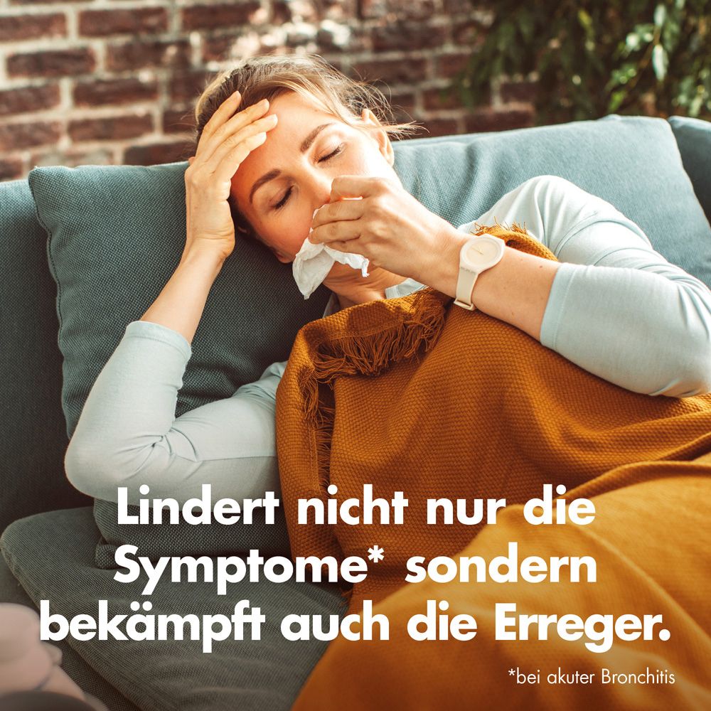 Eine Frau liegt auf einer Couch und putzt sich die Nase. Text: Lindert nicht nur die Symptome* sondern bekämpft auch die Erreger.
