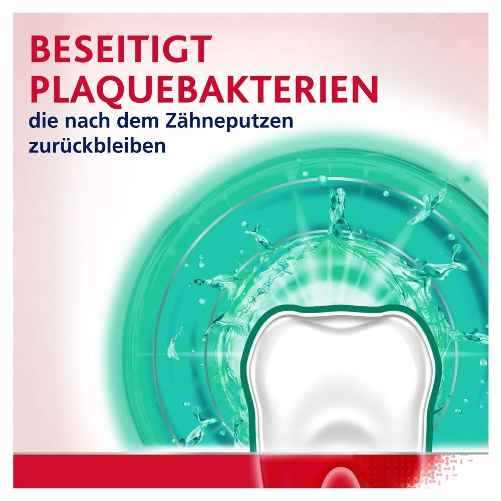 Nahaufnahme eines Zahns mit Wasserspritzern, die Plaque entfernen.