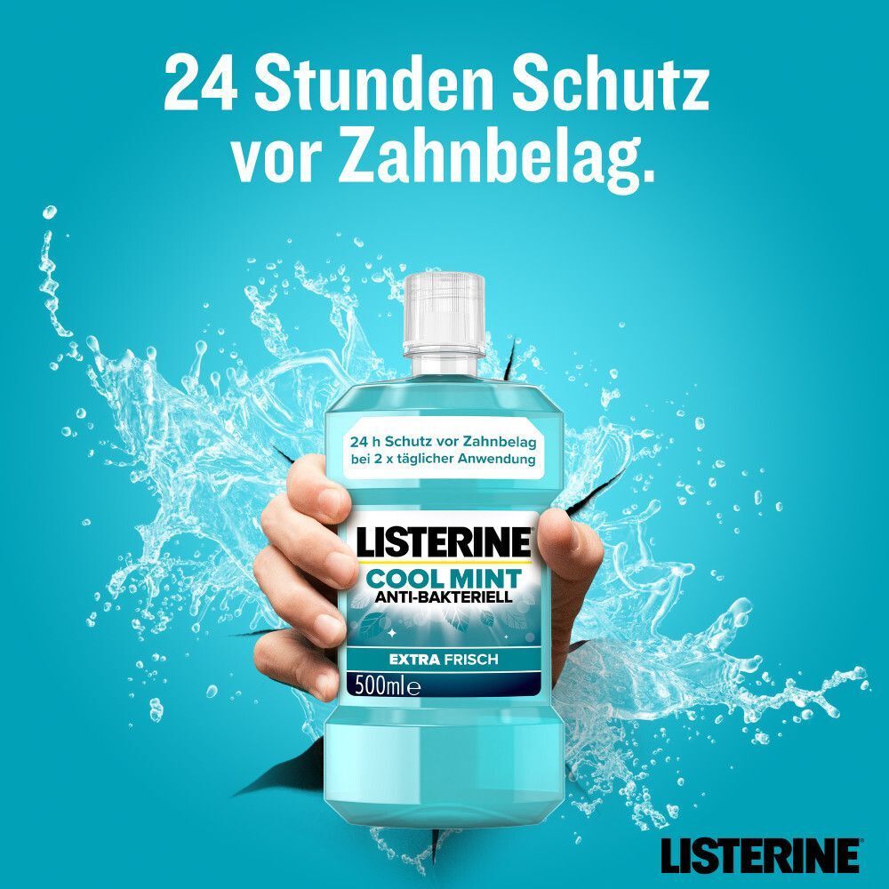 Hand hält Flasche LISTERINE® Cool Mint Anti-Bakteriell Extra Frisch (500ml) vor Wasserspritzern.