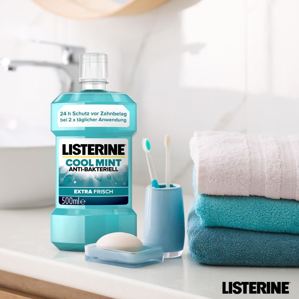 LISTERINE® Cool Mint Anti-Bakteriell Extra Frisch (500ml) im Badezimmer neben Handtüchern und Zahnbürsten.