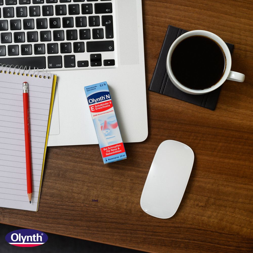 Olynth® N Nasenspray auf Tisch neben Laptop, Notizblock, Stift und Maus. Aufschrift: Olynth® N.