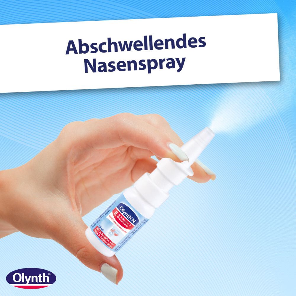 Hand hält eine Sprühflasche Olynth® N. Aufdruck: Abschwellendes Nasenspray. Sprühnebel sichtbar.