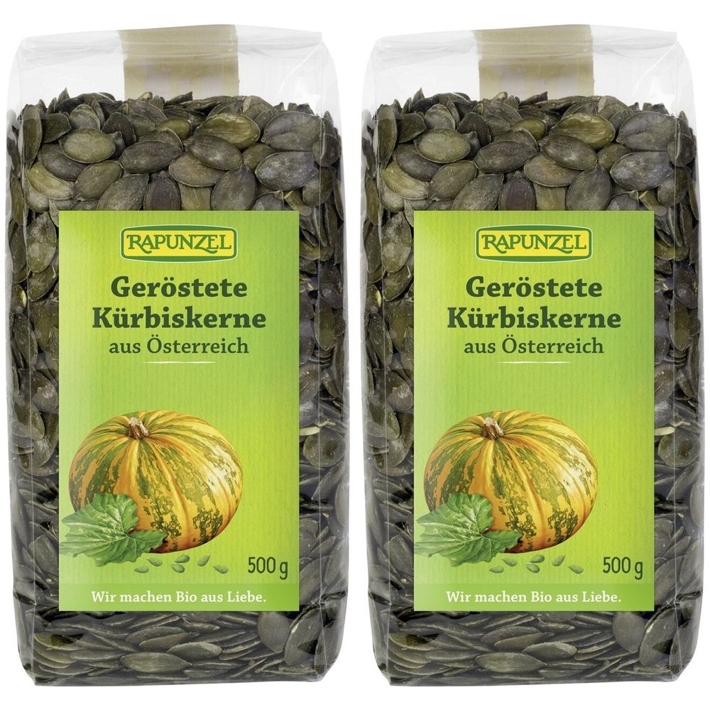 Zwei transparente Beutel mit gerösteten Kürbiskernen. Auf den Etiketten steht RAPUNZEL, Geröstete Kürbiskerne aus Österreich, 500g.