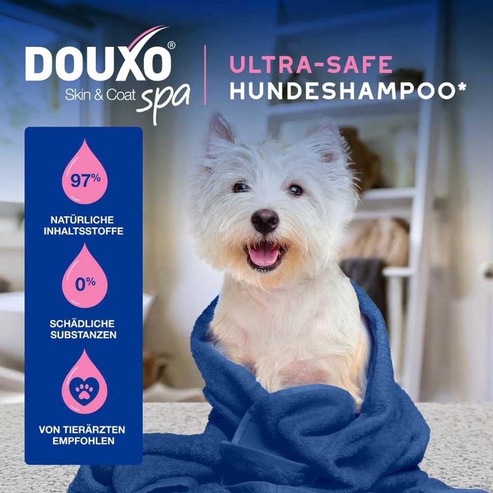 Weißer Hund in blauem Handtuch. Text: DOUXO® SPA Ultra-safe Hundeshampoo. 97% natürliche Inhaltsstoffe, 0% schädliche Substanzen.