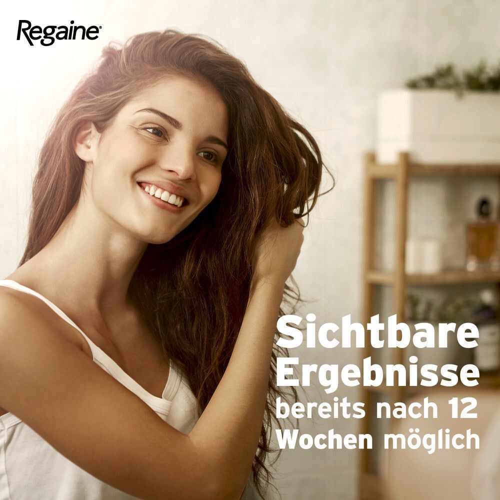 Lächelnde Frau mit langen, braunen Haaren, die sich durch die Haare fährt.