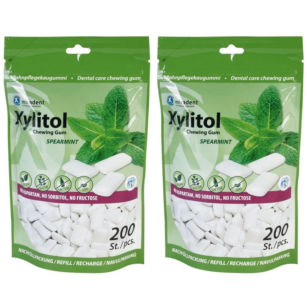 Zwei Beutel Kaugummi. Aufdruck: Xylitol, Spearmint, 200 Stück. Grün-weiße Verpackung mit Minzblatt-Illustration.