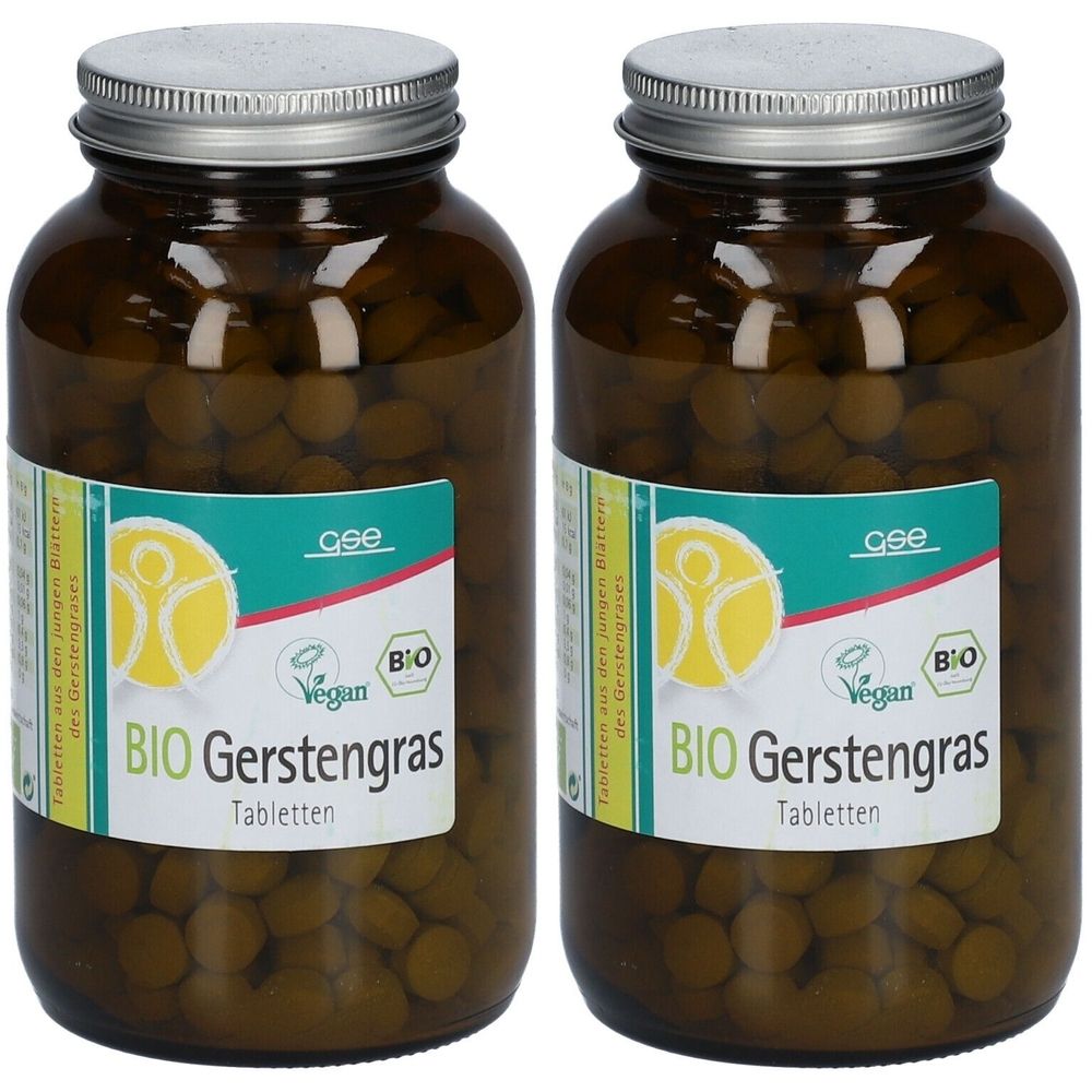 Zwei braune Glasflaschen mit Tabletten. Auf den Etiketten steht BIO Gerstengras, Vegan-Siegel und Bio-Siegel. Silberfarbene Schraubverschlüsse.