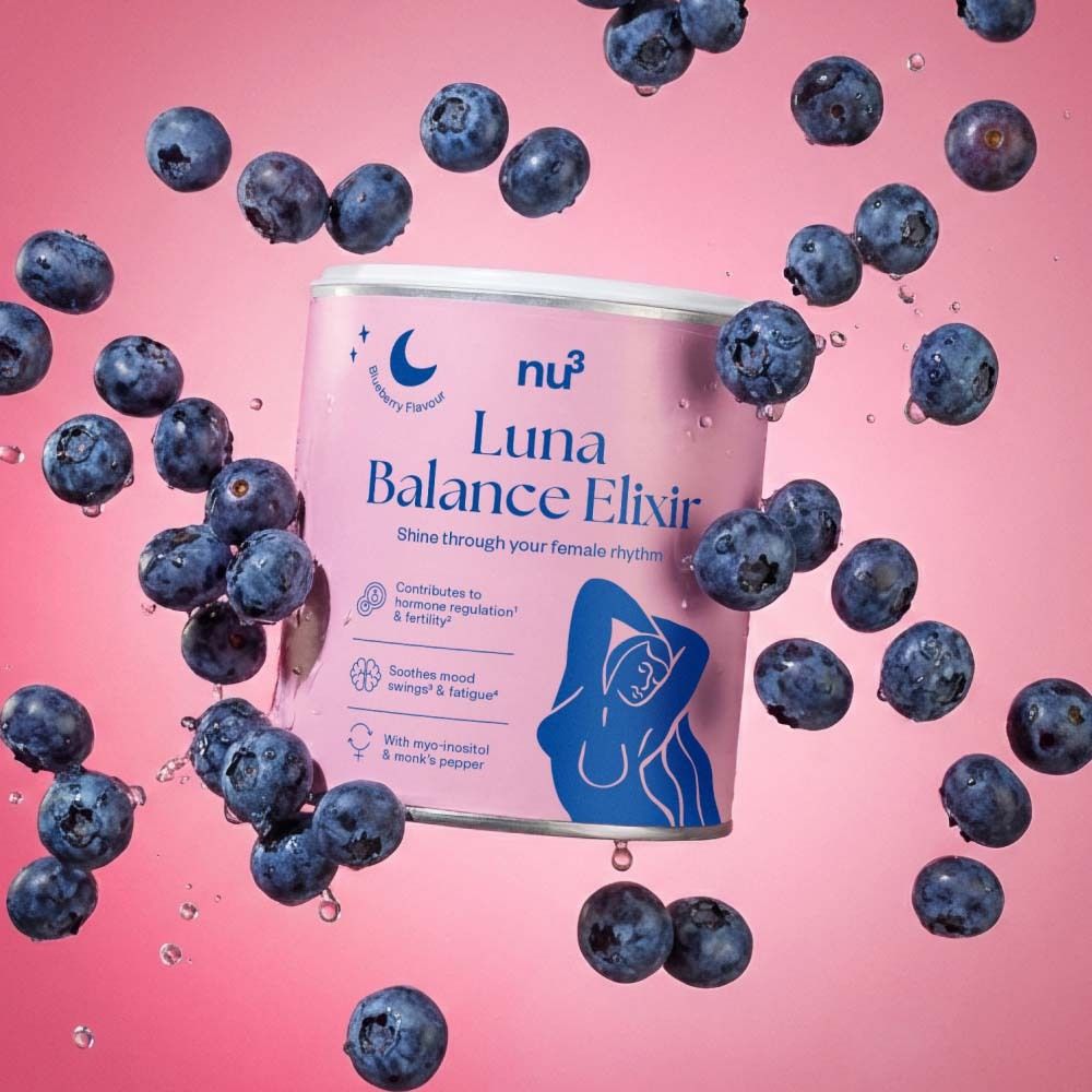 Rosa Dose mit weißem Deckel, umgeben von Blaubeeren. Aufschrift: nu3 Luna Balance Elixir. Enthält Informationen zu Hormonregulierung und Stimmungsschwankungen.