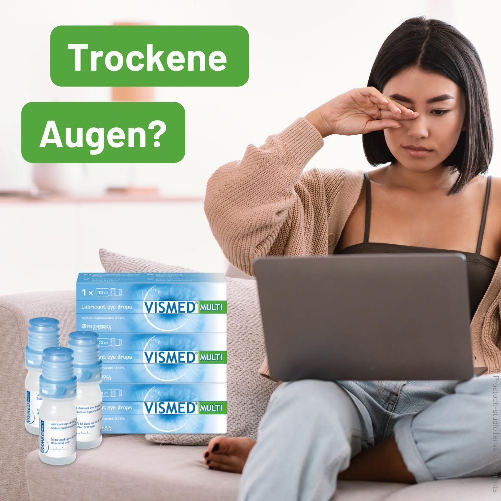 Frau reibt sich die Augen vor einem Laptop, daneben VISMED® MULTI Augentropfen.