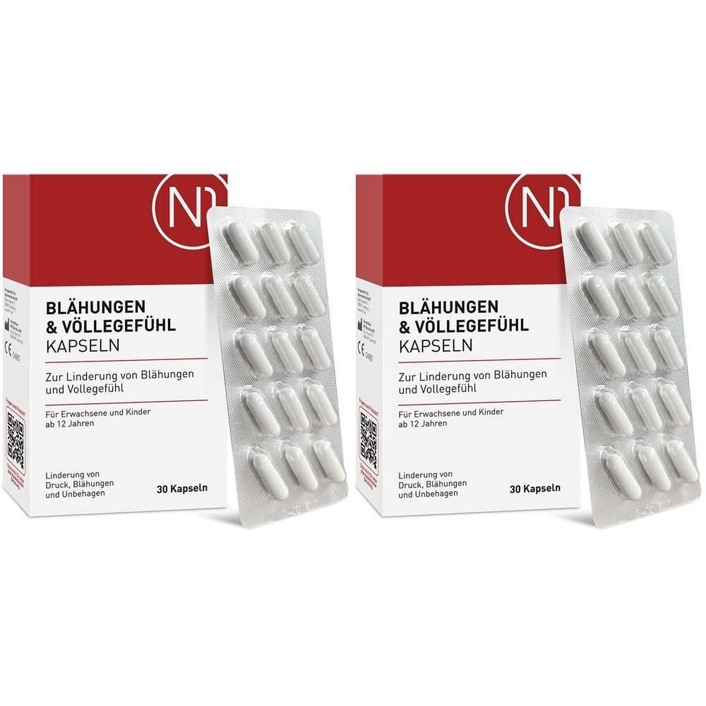 Zwei Packungen mit Kapseln. Aufschrift: Blähungen & Völlegefühl Kapseln. Weiße Kapseln in Blisterpackung. Rote und weiße Verpackung.