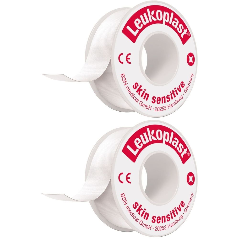 Zwei Rollen weißes Pflaster mit rotem Aufdruck „Leukoplast skin sensitive“. CE-Zeichen und Herstellerangaben sind sichtbar.