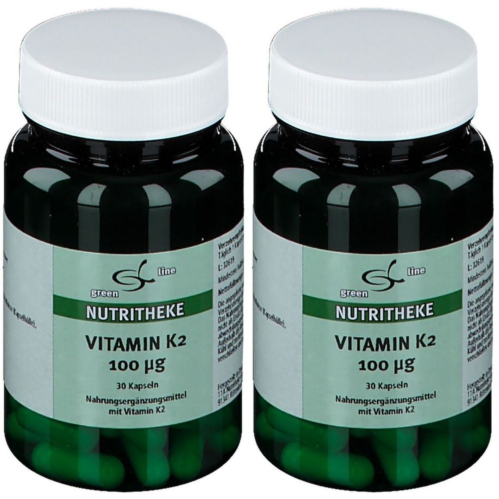 Zwei Flaschen mit Vitamin K2-Kapseln. Grüne Kapseln in grünen Glasflaschen mit weißen Deckeln. Aufschrift: NUTRITHEKE, Vitamin K2, 100 µg.