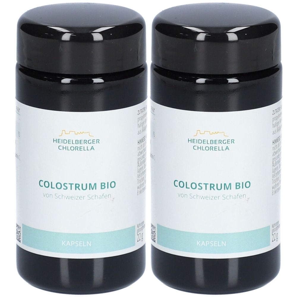 Zwei schwarze Flaschen mit weißen Etiketten. Aufschrift: COLOSTRUM BIO, Kapseln. Marke: HEIDELBERGER CHLORELLA.