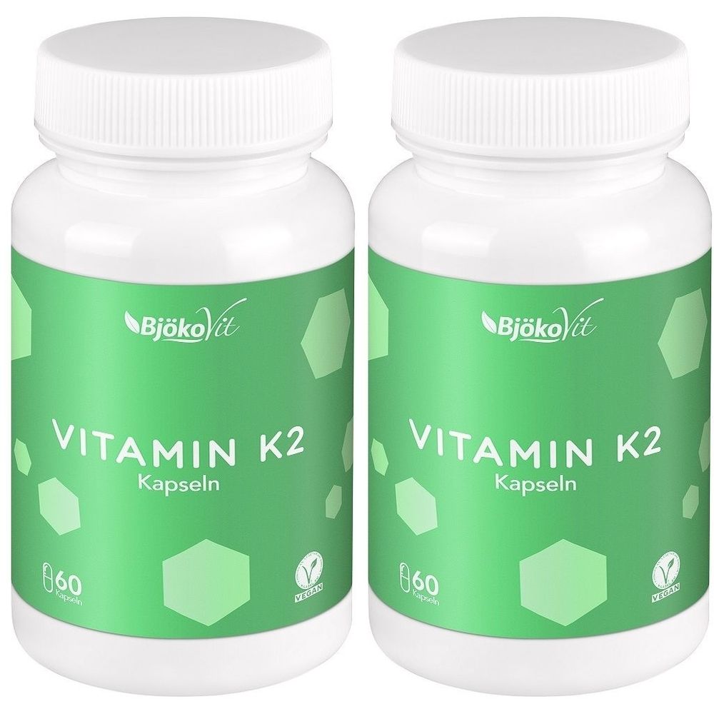 Zwei weiße Flaschen mit Schraubverschluss. Aufschrift: Vitamin K2 Kapseln. Marke: BjökoVit. Grün-weißes Etikett mit 60 Kapseln.