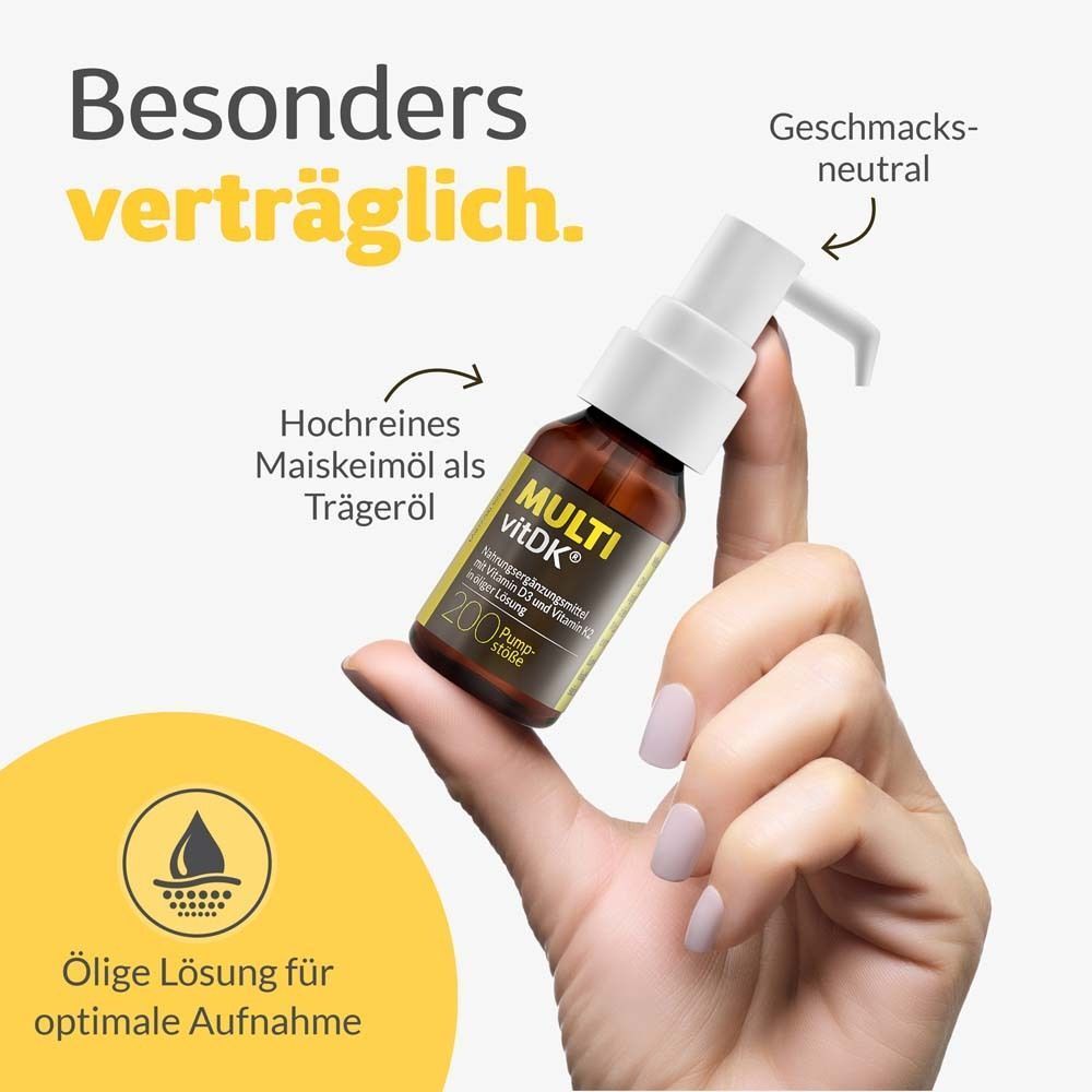 Hand hält MULTI vitDK® Flasche mit Pumpspender, öliger Lösung für optimale Aufnahme, geschmacksneutral.