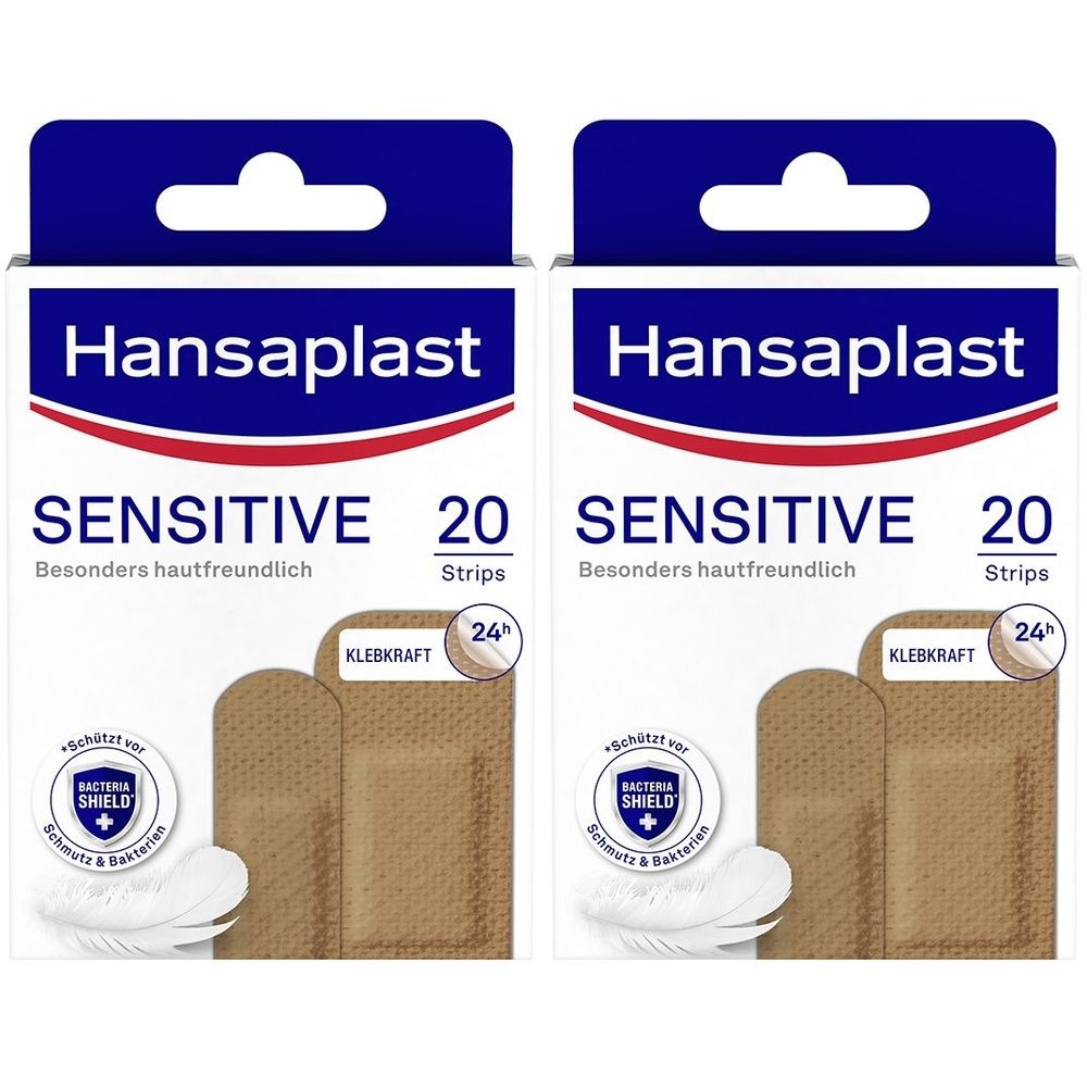 Zwei Packungen Pflaster. Aufschrift: Hansaplast Sensitive, 20 Strips. Mit Klebkraft- und Bacteria Shield-Symbolen. Pflaster in Hautton.