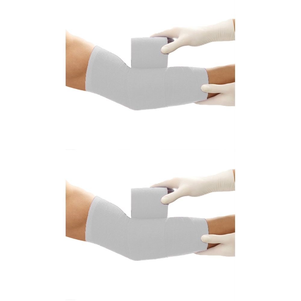 Arm mit weißer Bandage. Eine Hand mit Handschuh hält einen Würfel. Zweite Hand mit Handschuh hält Arm.