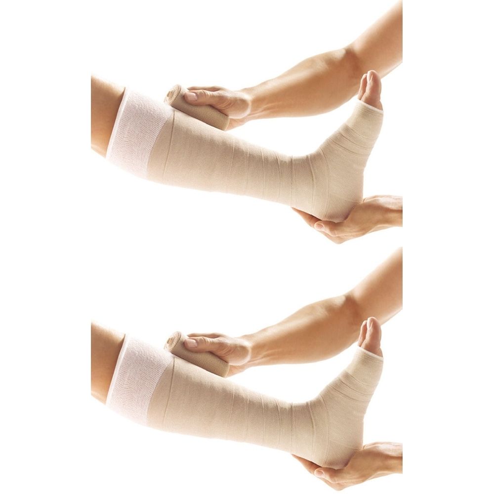 Zwei Beine mit Bandagen. Hände halten und wickeln die Bandage um Bein und Fuß. Beige Bandage.