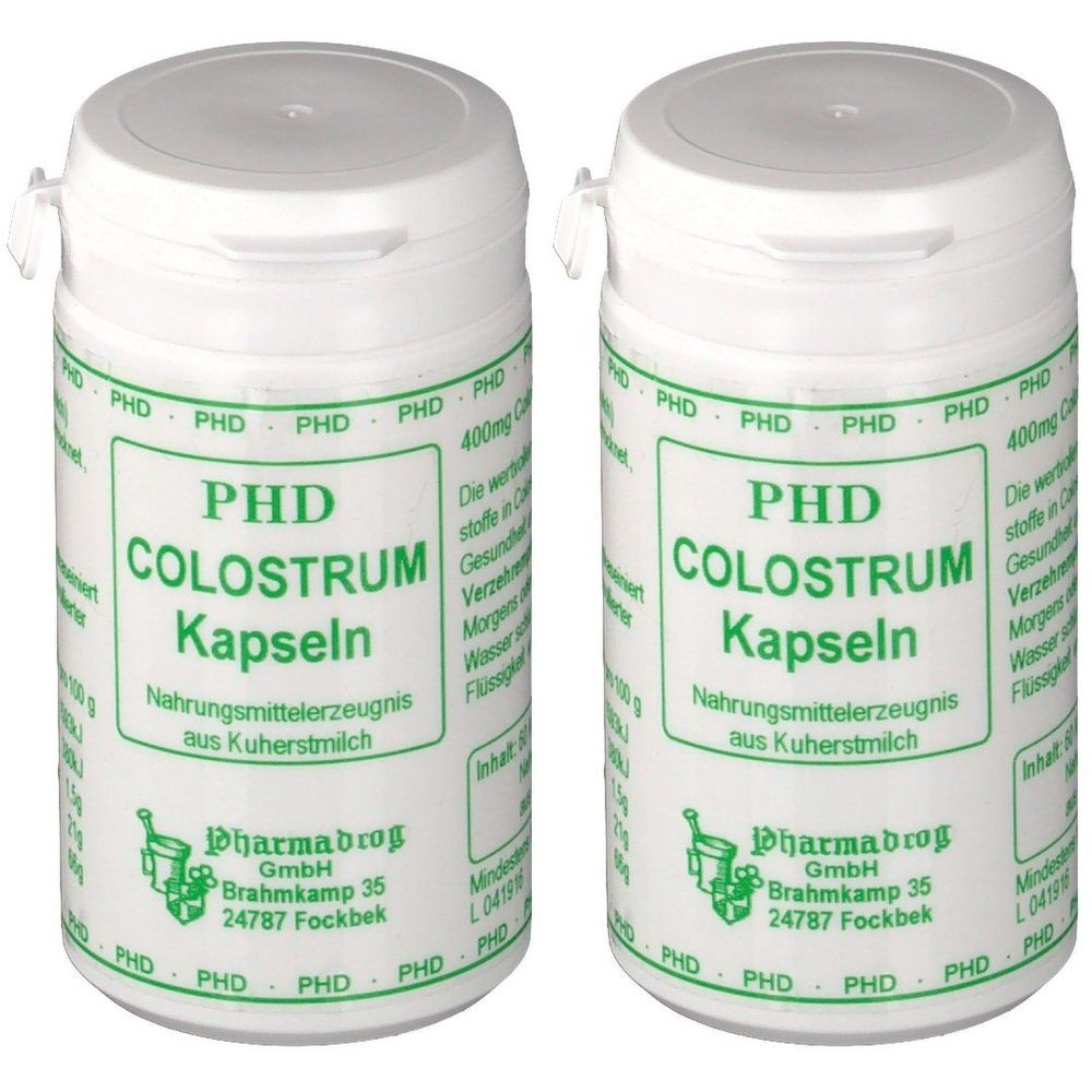 Zwei weiße Behälter mit Deckel. Aufschrift: PHD Colostrum Kapseln. Grüne Schrift auf weißem Hintergrund. Hersteller: Pharmabrog GmbH.