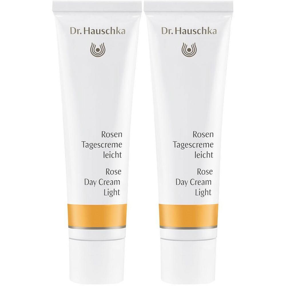 Zwei weiße Tuben Dr. Hauschka Rosen Tagescreme leicht mit orangefarbenem Band.