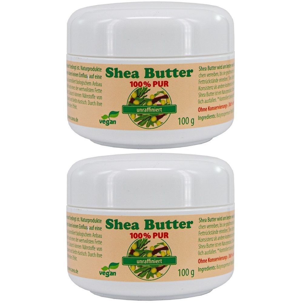 Zwei weiße Tiegel mit Aufschrift Shea Butter 100% PUR, unraffiniert. Vegan-Siegel. 100 g. Aufschrift in Deutsch.