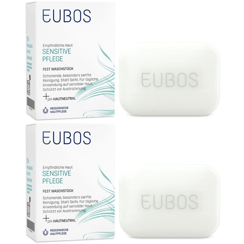 Zwei weiße Seifenstücke und zwei Produktverpackungen. Auf den Verpackungen steht "EUBOS Sensitive Pflege". Die Seifen haben abgerundete Ecken.