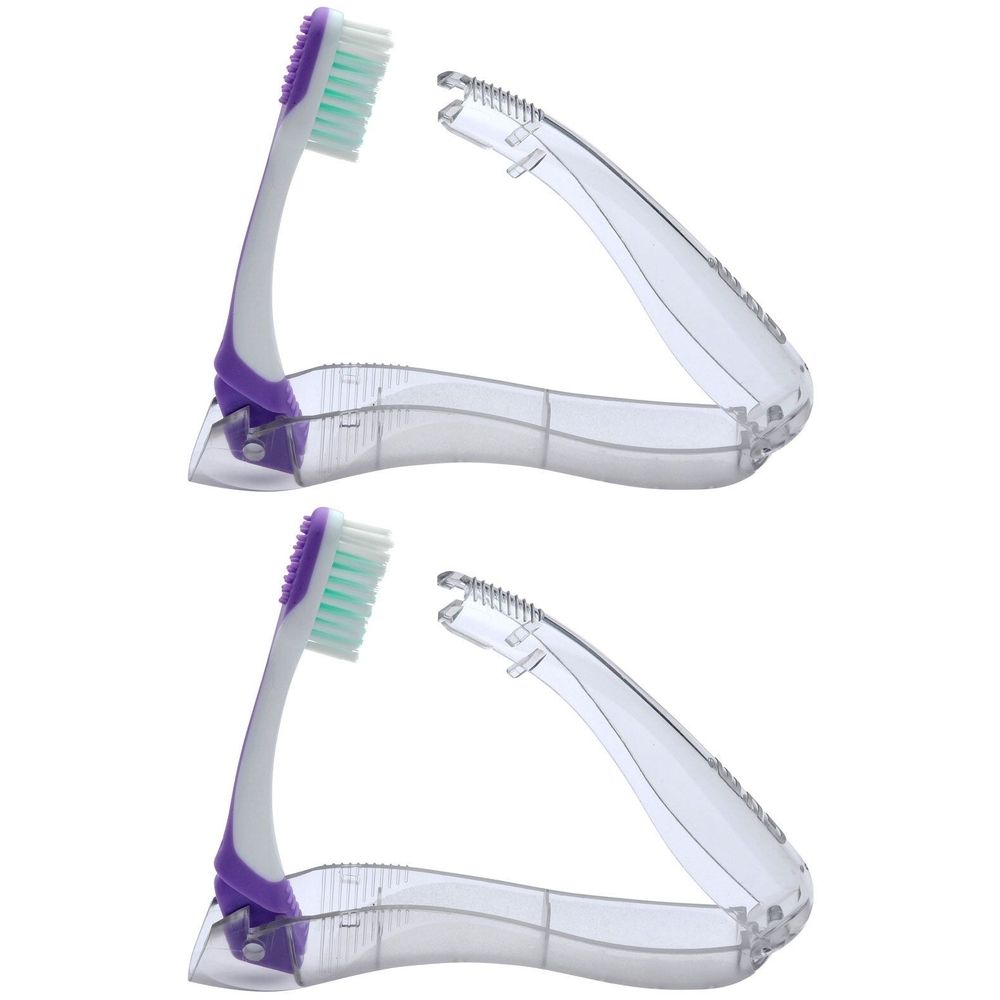 Zwei zusammenklappbare Zahnbürsten mit lila Griffen und transparenten Schutzhüllen. Die Borsten sind grün und lila.
