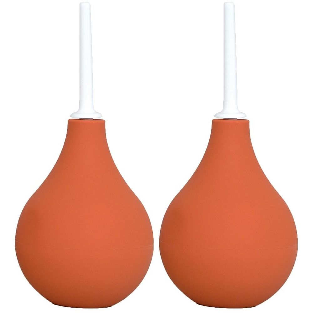 Zwei orangefarbene Klistierspritzen mit weißen Applikatoren. Birnenförmiger Körper, konisch zulaufend. Auf weißem Hintergrund.