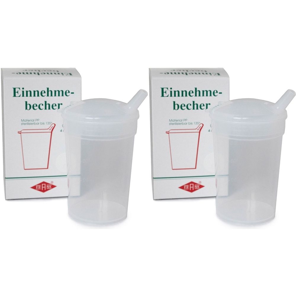 Zwei transparente Trinkbecher mit Deckel und Strohhalm, neben zwei weißen Schachteln mit Aufschrift "Einnehmebecher".