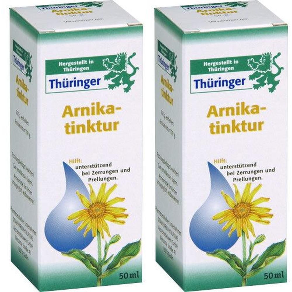 Zwei Schachteln mit "Thüringer Arnikatinktur". Weiße Verpackung mit grünen und gelben Akzenten. Text und Illustrationen.