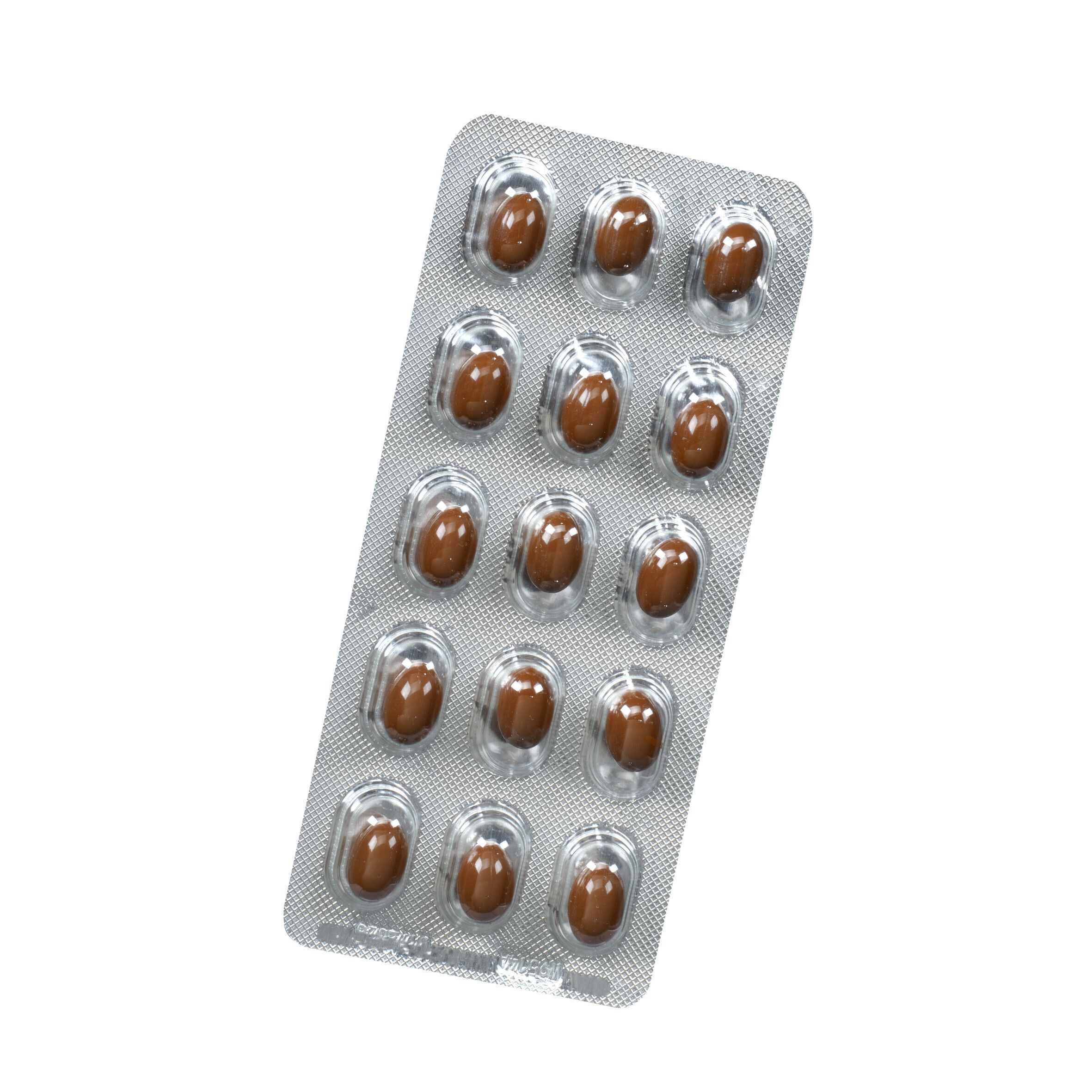 Blisterpackung mit Kapseln. Braune Kapseln in transparenten Vertiefungen. Silberfarbener Hintergrund.