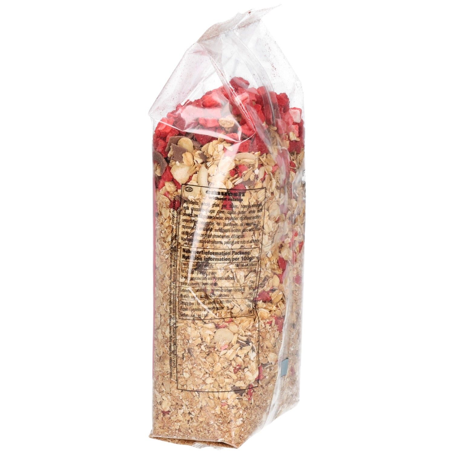 Transparente Verpackung mit Müsli, Seitenansicht. Haferflocken, Erdbeerstücke und Schokostückchen sichtbar. Text auf der Verpackung.
