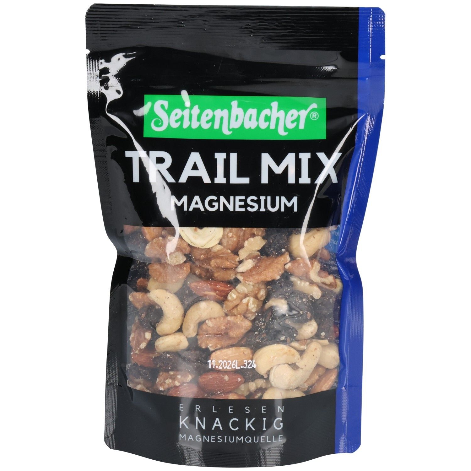 Schwarze Tüte mit Seitenbacher Trail Mix. Enthält Nüsse, Rosinen und Magnesium. Grün-weißer Markenname. Blaue Akzente.