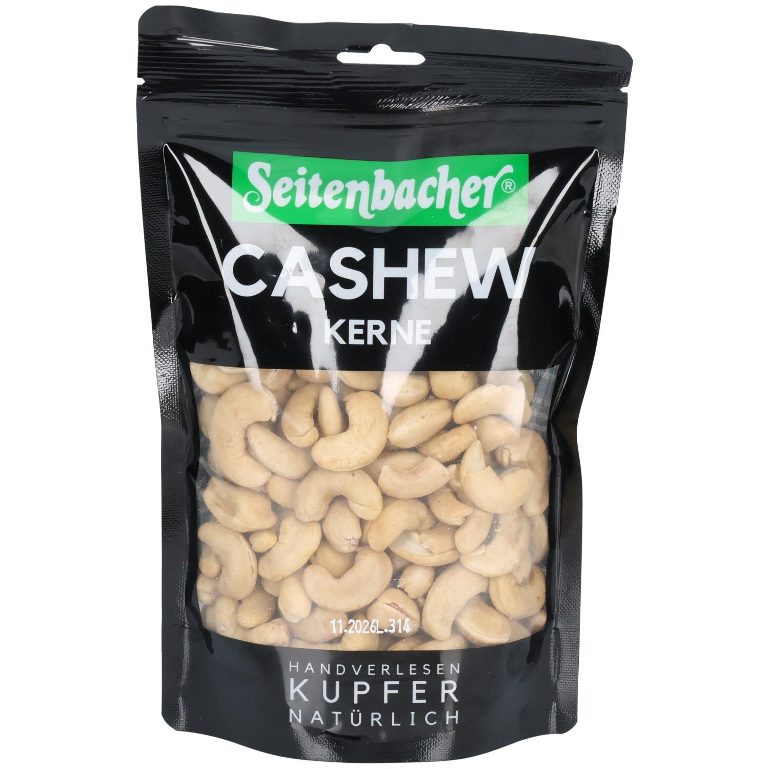 Schwarze Tüte mit Cashewkernen. Seitenbacher-Logo und Produktbezeichnung. Sichtfenster mit Cashewkernen. Handverlesen, Kupfer, natürlich.