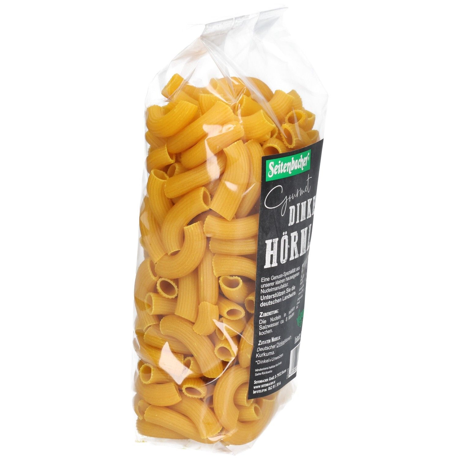 Klare Plastiktüte mit Seitenbacher Dinkel Hörnle Nudeln. Die Nudeln sind gebogen und gelb. Verpackung schräg von der Seite.