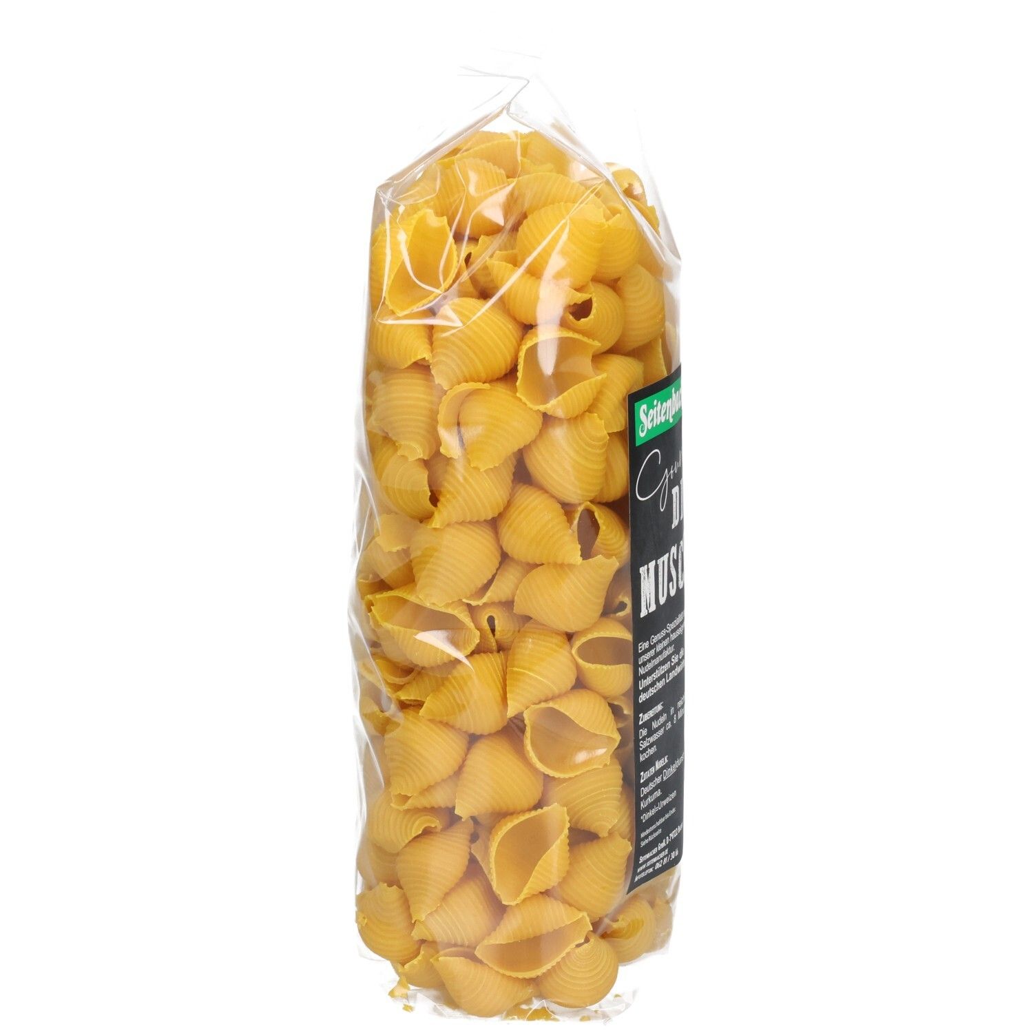 Klarsichtbeutel mit Seitenbacher Dinkel Muscheln, Seitenansicht. Schwarzes Etikett mit Produktinformationen.