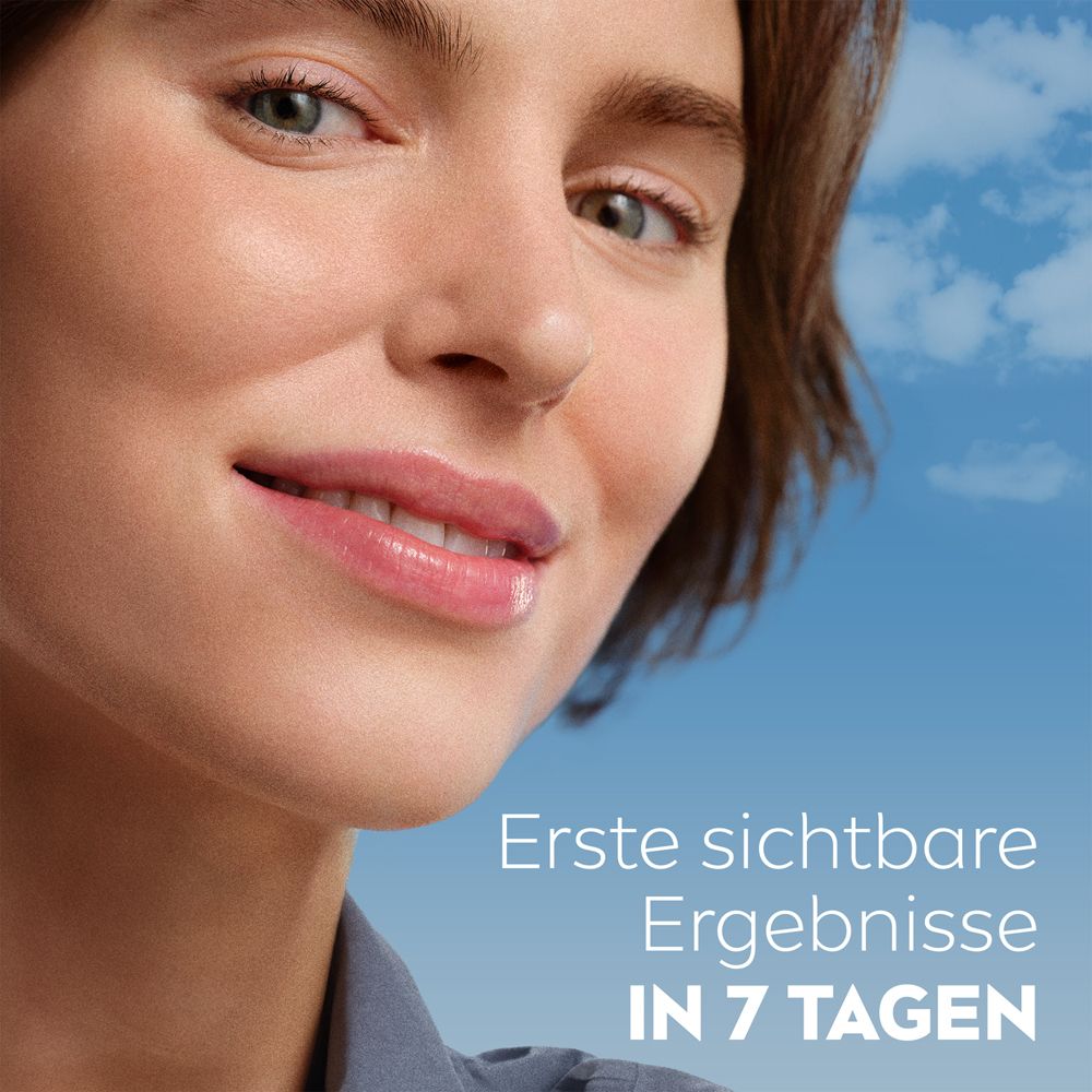 Zwei Frauen unterschiedlicher Hauttypen mit blauem Himmel im Hintergrund.