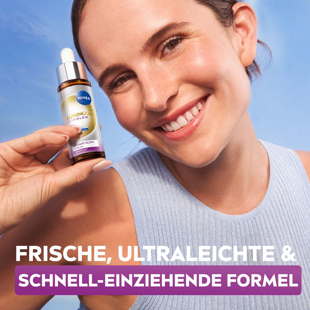 Frau hält NIVEA LUMINOUS630® Instant Glow Serum Flasche, strahlendes Hautbild.
