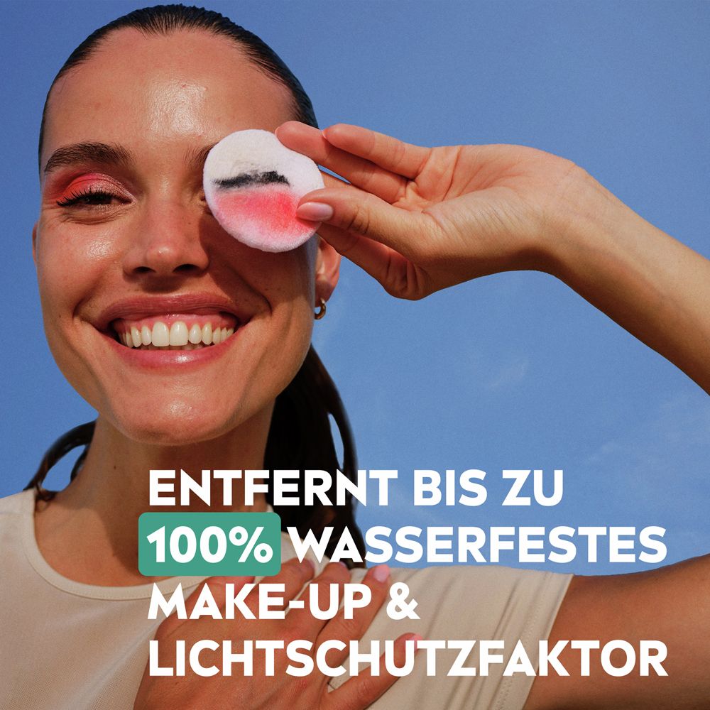 Frau mit Make-up wischt sich mit einem Wattepad über das Auge. Text: Entfernt bis zu 100% wasserfestes Make-up.