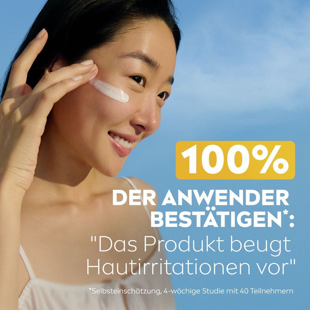 Frau mit Creme im Gesicht. 100% bestätigen: Das Produkt beugt Hautirritationen vor.