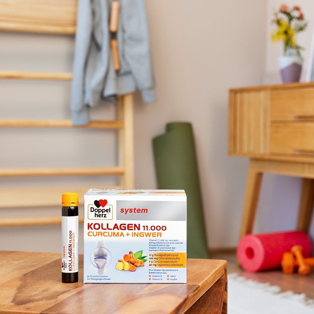 Trinkfläschchen und Packung Doppelherz system KOLLAGEN 11.000 CURCUMA + INGWER auf einem Tisch in einem Wohnzimmer.
