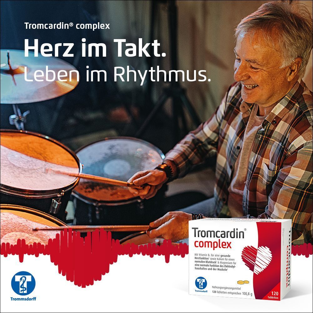 Mann spielt Schlagzeug, daneben Tromcardin® complex Packung. Weiße Schachtel mit Herz.