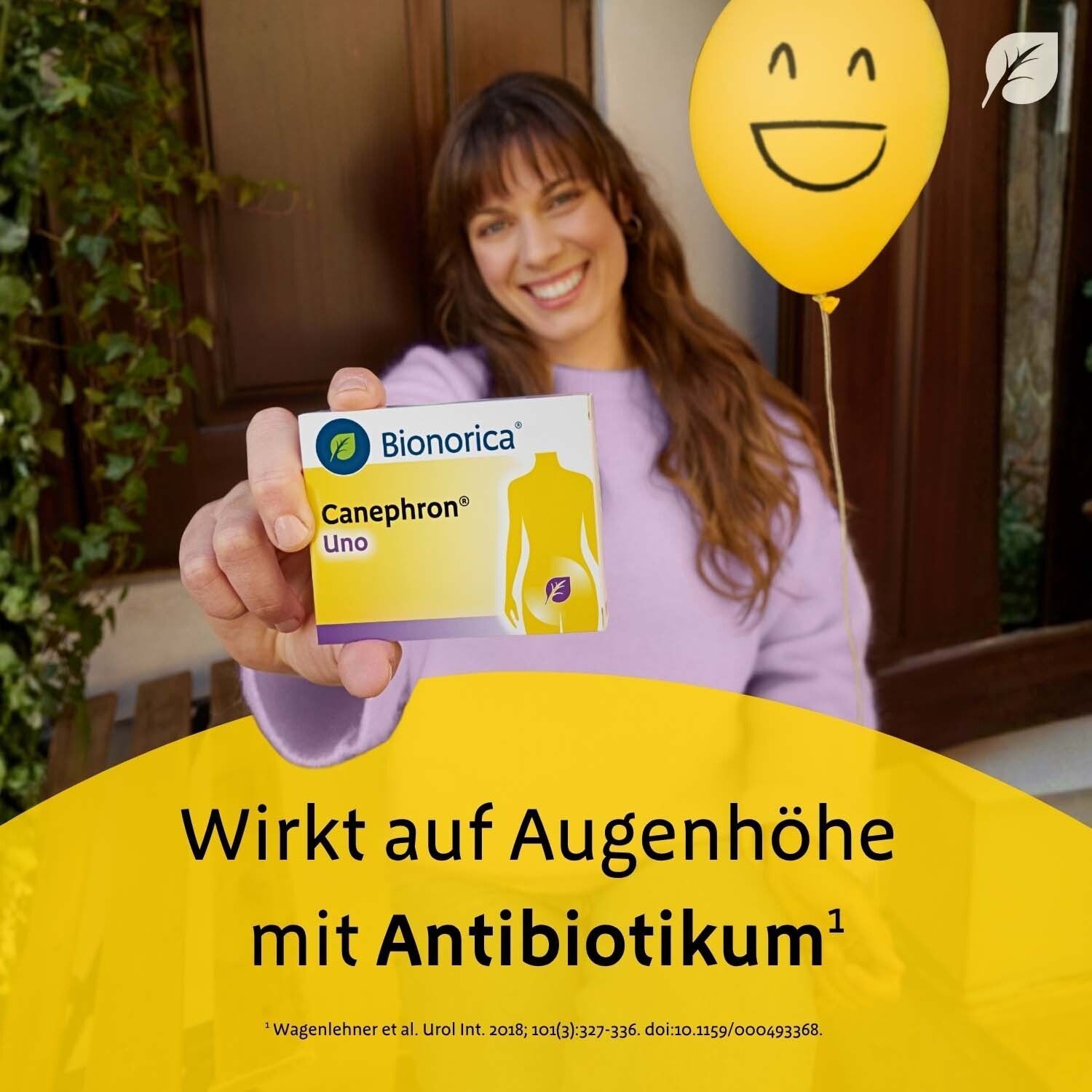 Frau hält eine Packung Canephron Uno. Text: Wirkt auf Augenhöhe mit Antibiotikum. Gelber Ballon mit Gesicht.