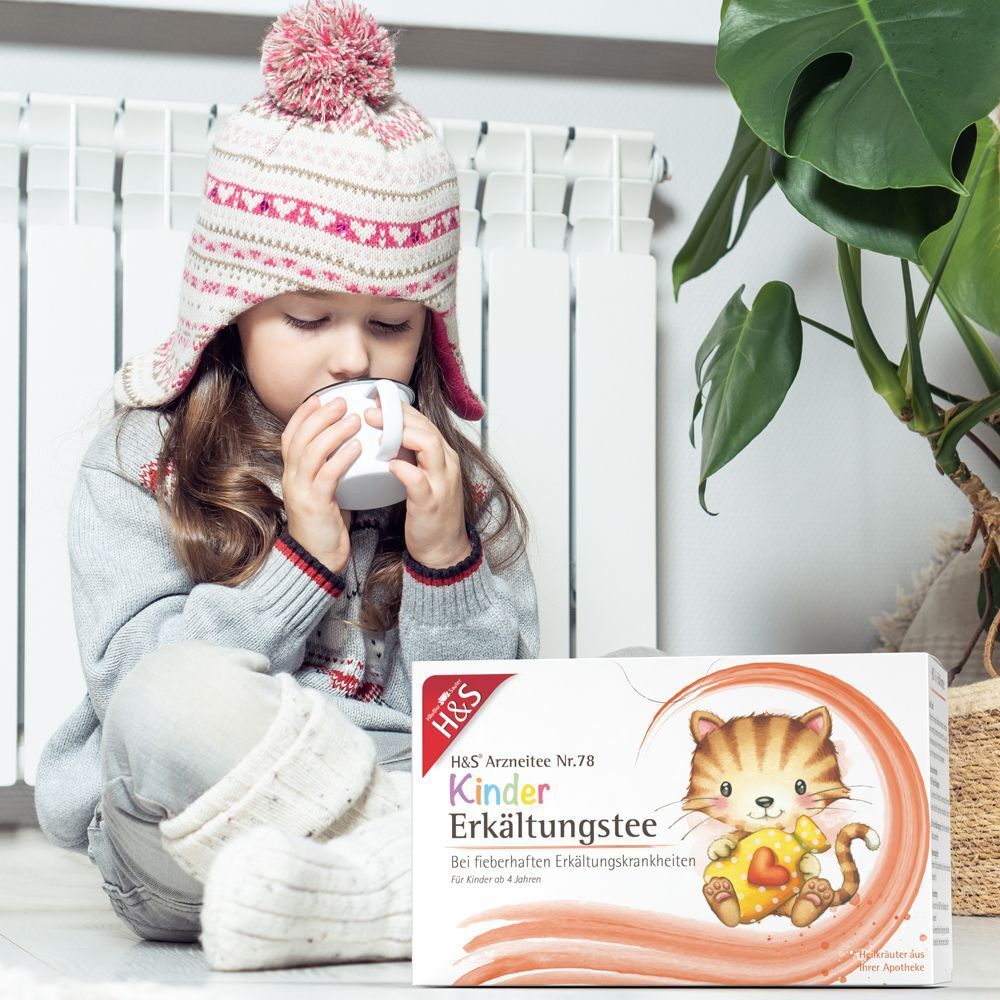 Kind trinkt Tee neben H&S Kinder Erkältungstee Packung.