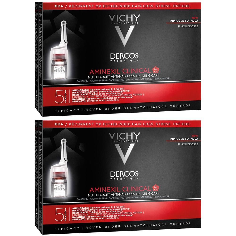 Zwei Packungen VICHY Dercos Aminexil Clinical 5. Schwarze Verpackung mit roter Schrift. Enthält 21 Monodosen. Aufschrift: Multi-Target Anti-Haarausfall-Pflege.