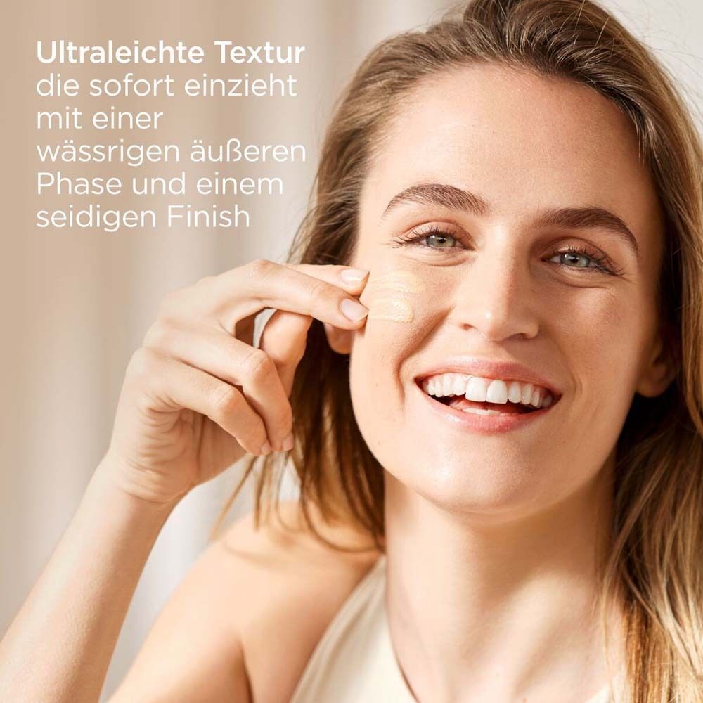 Frau trägt Produkt auf. Text: Ultraleichte Textur, die sofort einzieht mit einer wässrigen äußeren Phase und einem seidigen Finish.