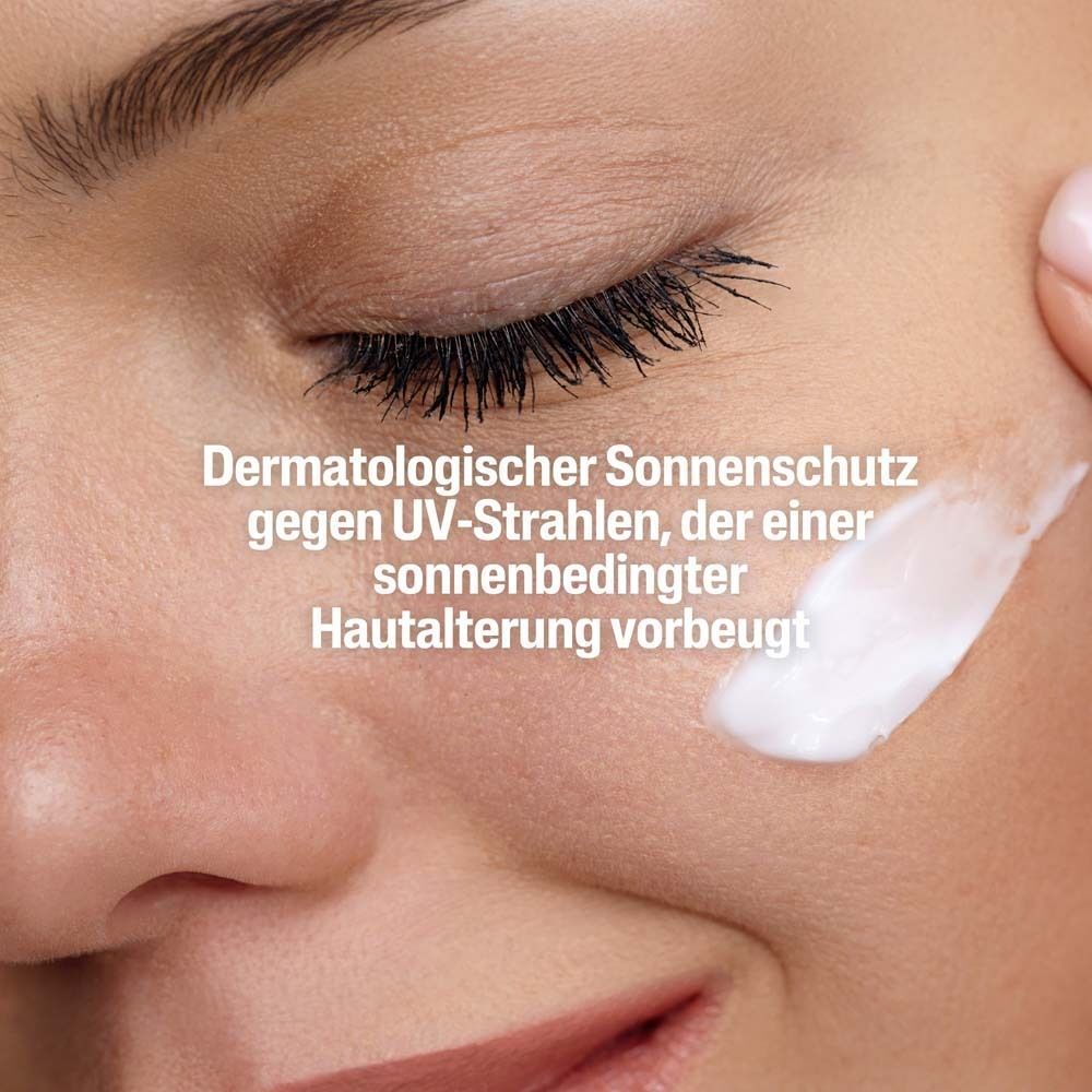Nahaufnahme eines Gesichts mit Creme. Text: Dermatologischer Sonnenschutz gegen UV-Strahlen, der Hautalterung vorbeugt.