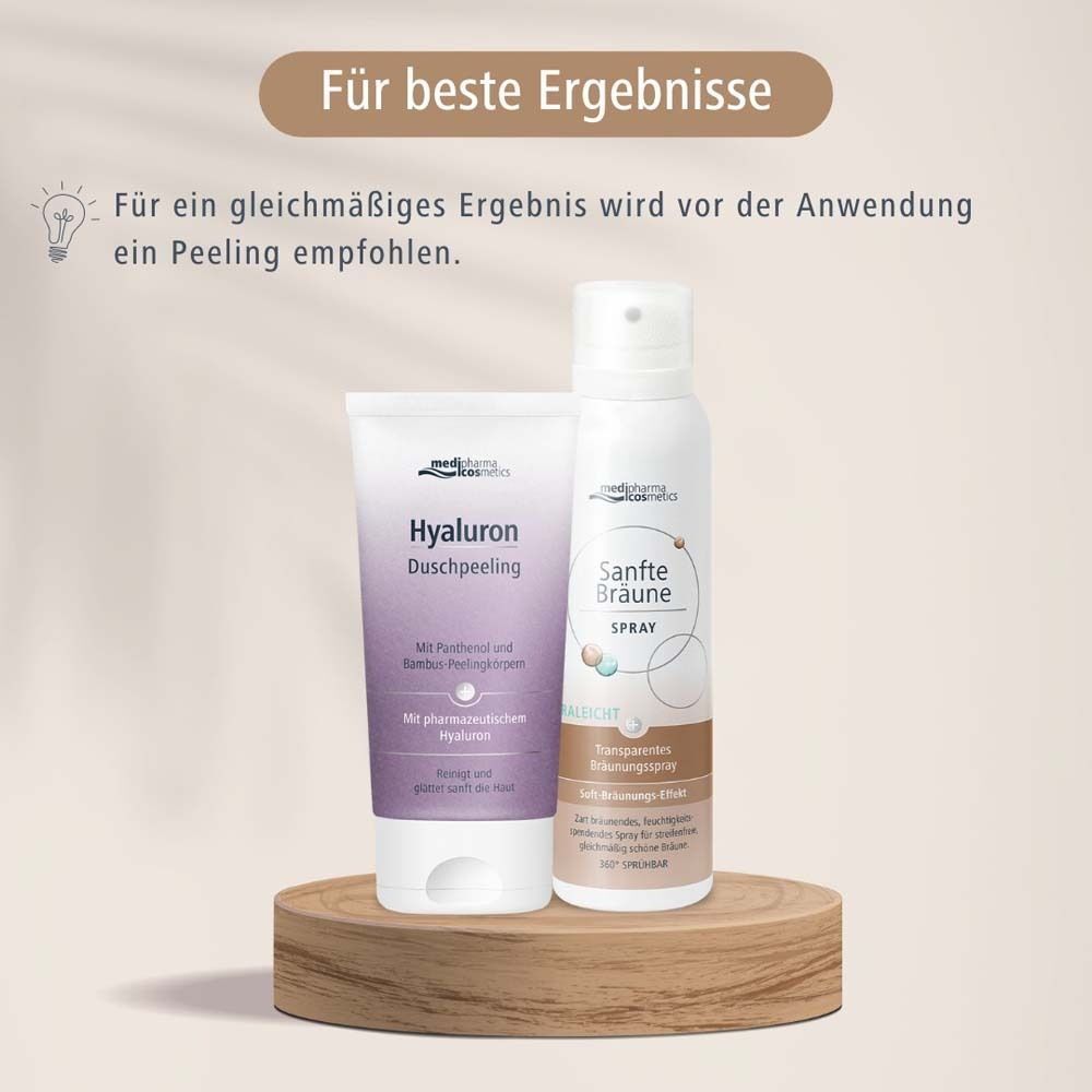 Sprühflasche "Sanfte Bräune Spray" und Tube "Hyaluron Duschpeeling" auf Holzsockel. Produktabbildung.