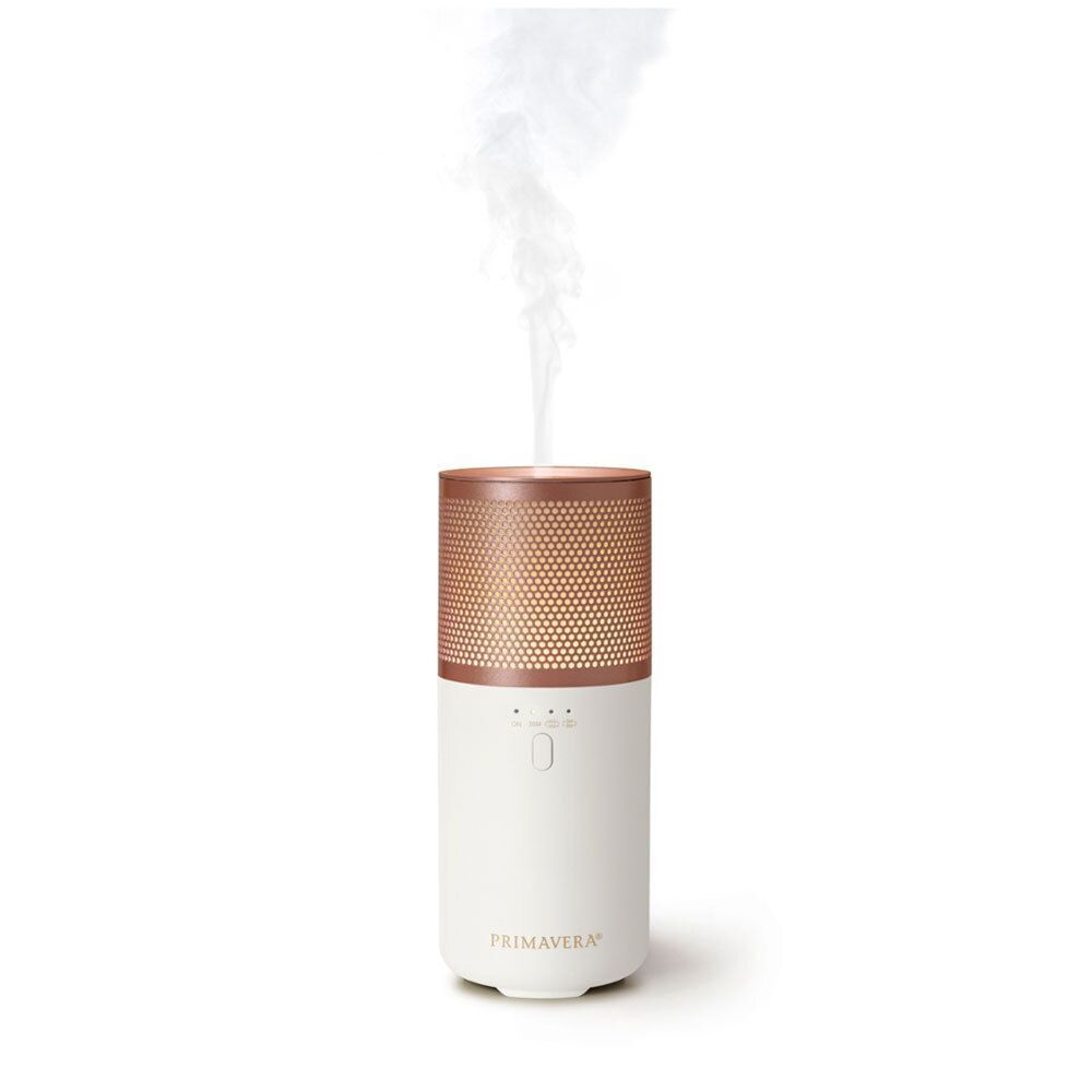 Aroma Vernebler, weißes Gehäuse mit kupferfarbenem Gitter. Dampf steigt auf. Text: PRIMAVERA.